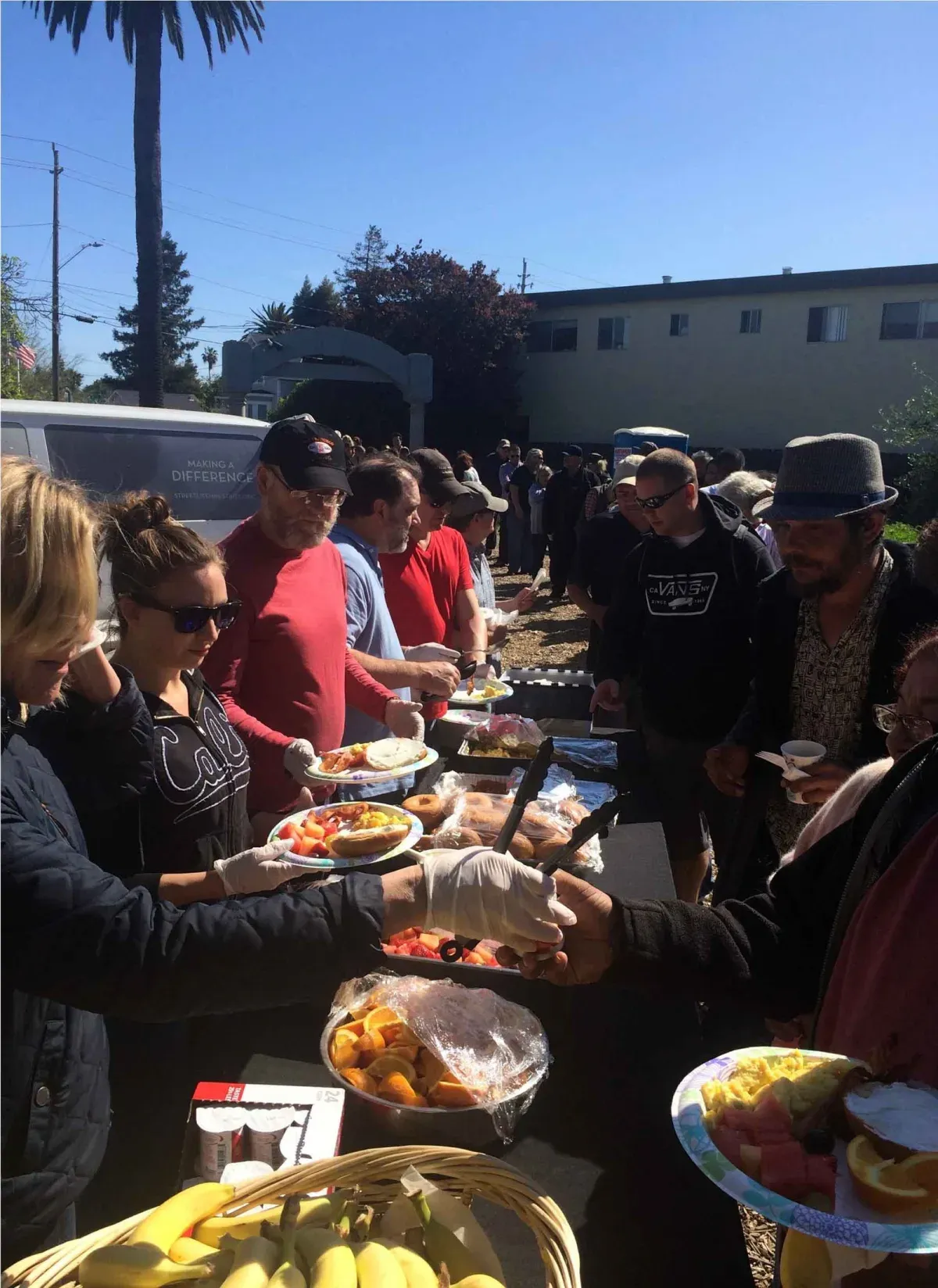 Volunteers and friends from the street sharing a meal together at an outdoor Street Life Ministries service